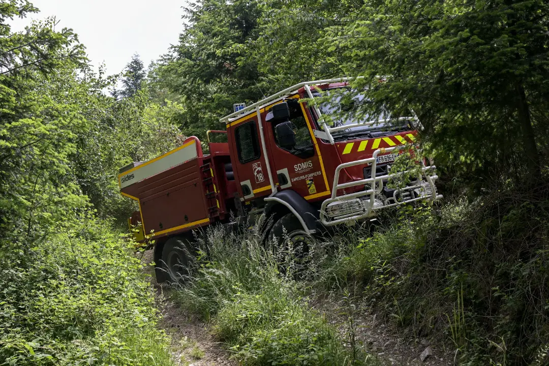 Camion de pompiers (CCF) manoeuvrant sur une piste étroite dans une forêt septentrionale