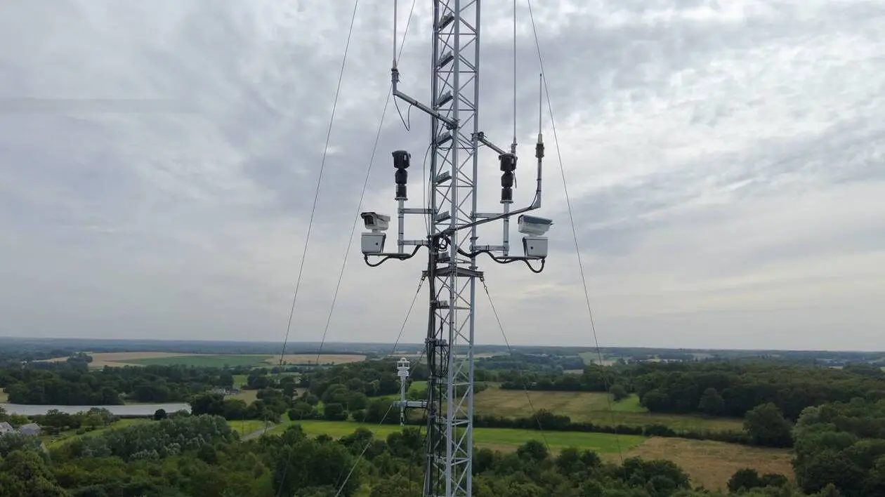 Un pylône de détection équipé de caméras optiques et thermiques dominant un massif forestier